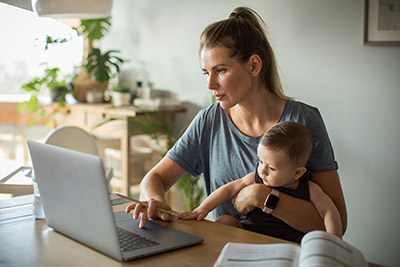 Image of telecommuter on laptop with infant