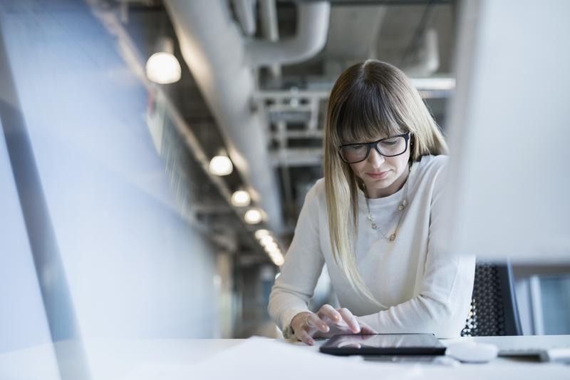 Image of a woman using a tablet device in a workplace setting