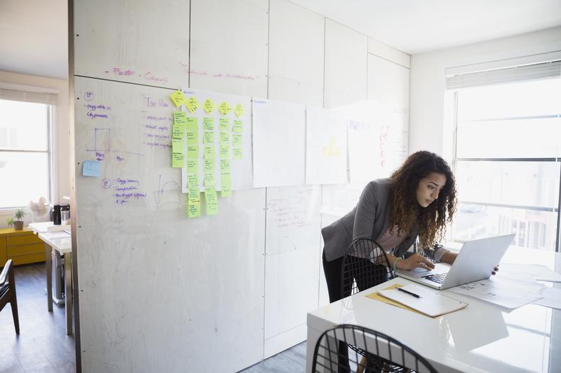 Image of woman studying project files on a desk